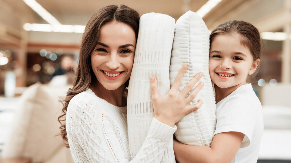Smiling little girl hugs pillow